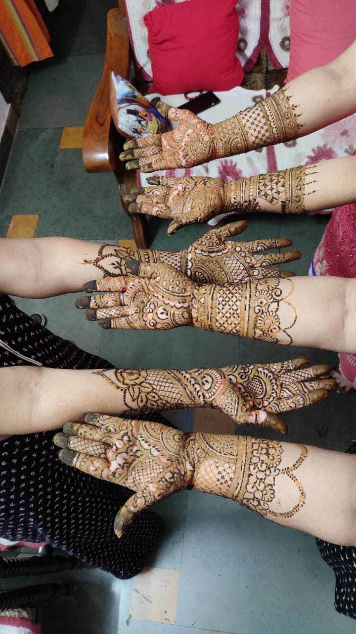 Traditional mehndi designs on multiple hands after a family bridal session
