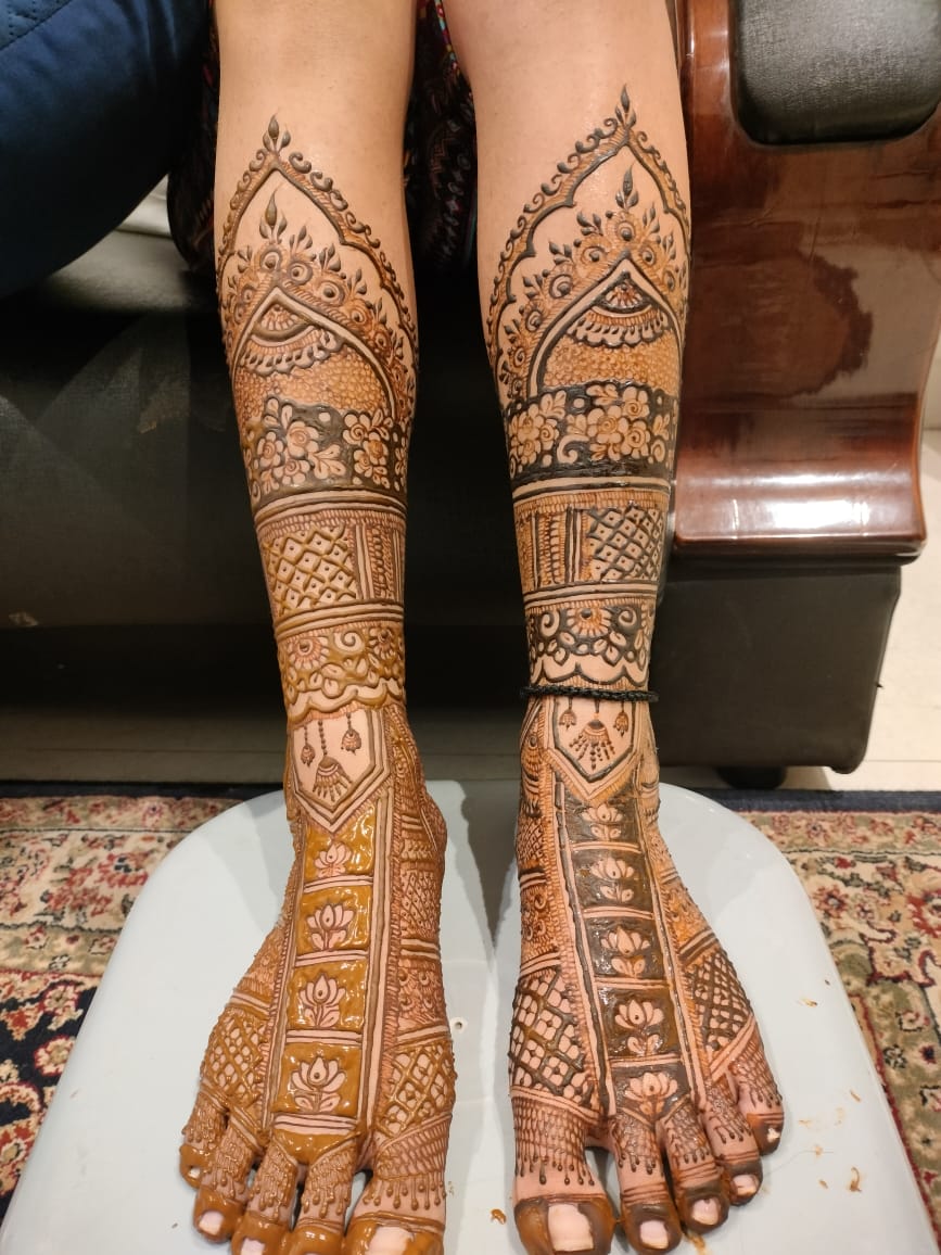 Detailed bridal foot and leg mehndi with lotus and jaali panels