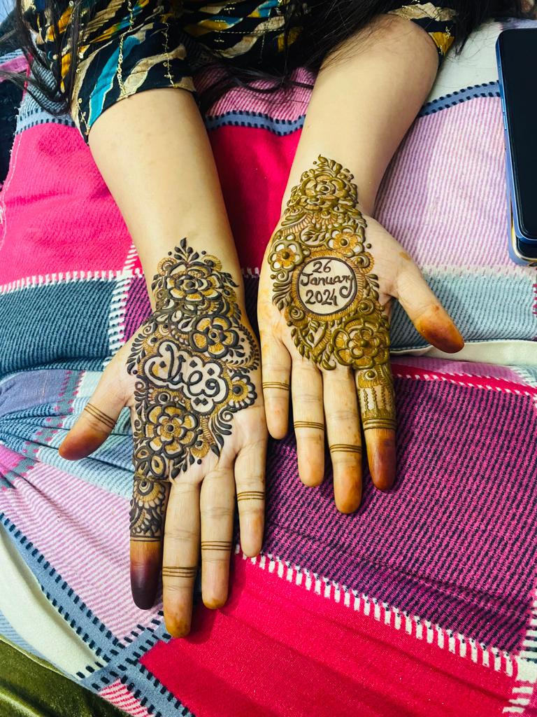 Minimal back-hand mehndi with floral cluster and personalised date design